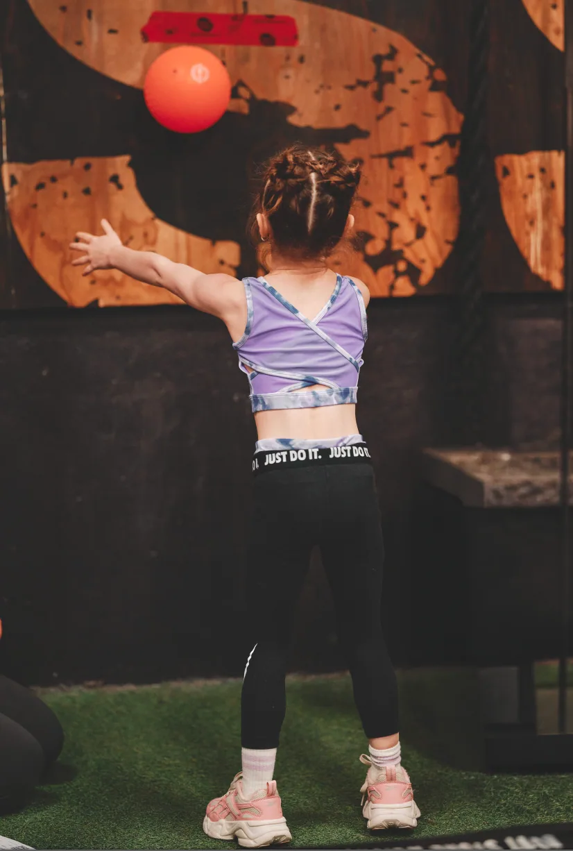 Jeune athlète en position pour un wall ball au CrossFit Chicoutimi.