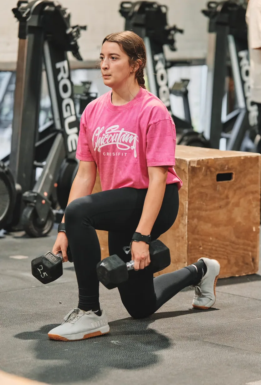 Athlète qui exécute un lunge avec haltères, t-shirt CrossFit Chicoutimi.